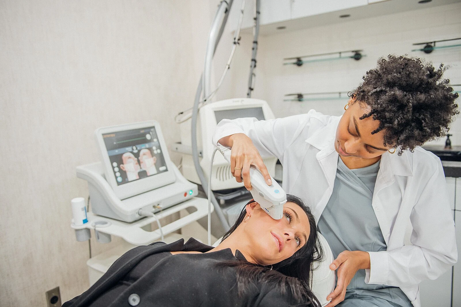 Professional aesthetics doctor performing Ultherapy on a relaxed female patient’s lower face in a modern, softly lit treatment room.